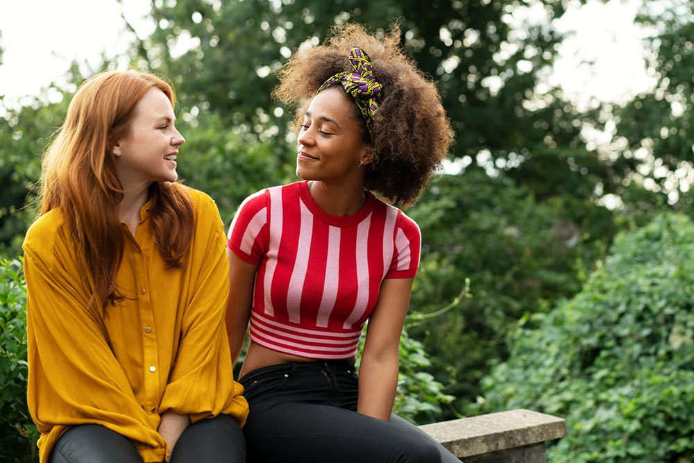 Två kvinnor som sitter på en bänk